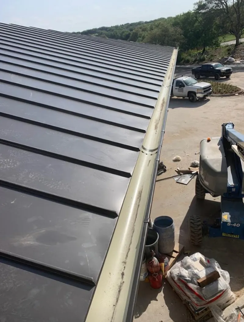 Standing seam panel and gutter detail on a metal roofing jobsite in Pinole